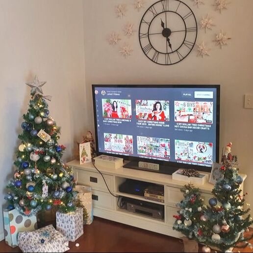 TV surrounded by a Christmas forest in Blue pink and red.