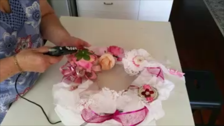 Hot gluing embellishments to the wreath.