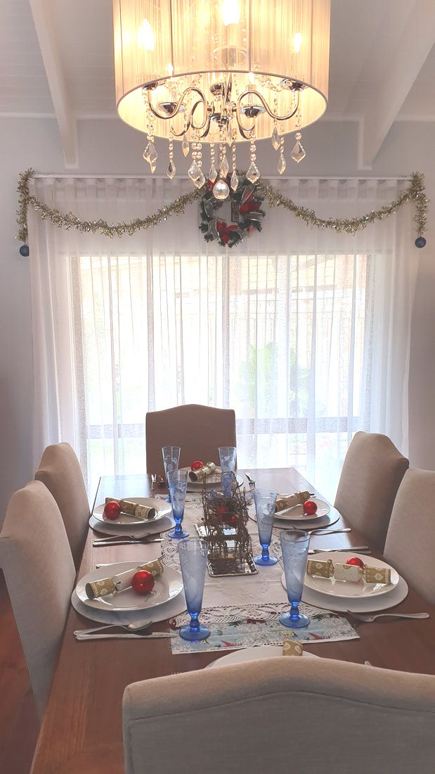 Dining room table and window decorated in blue and red for Christmas