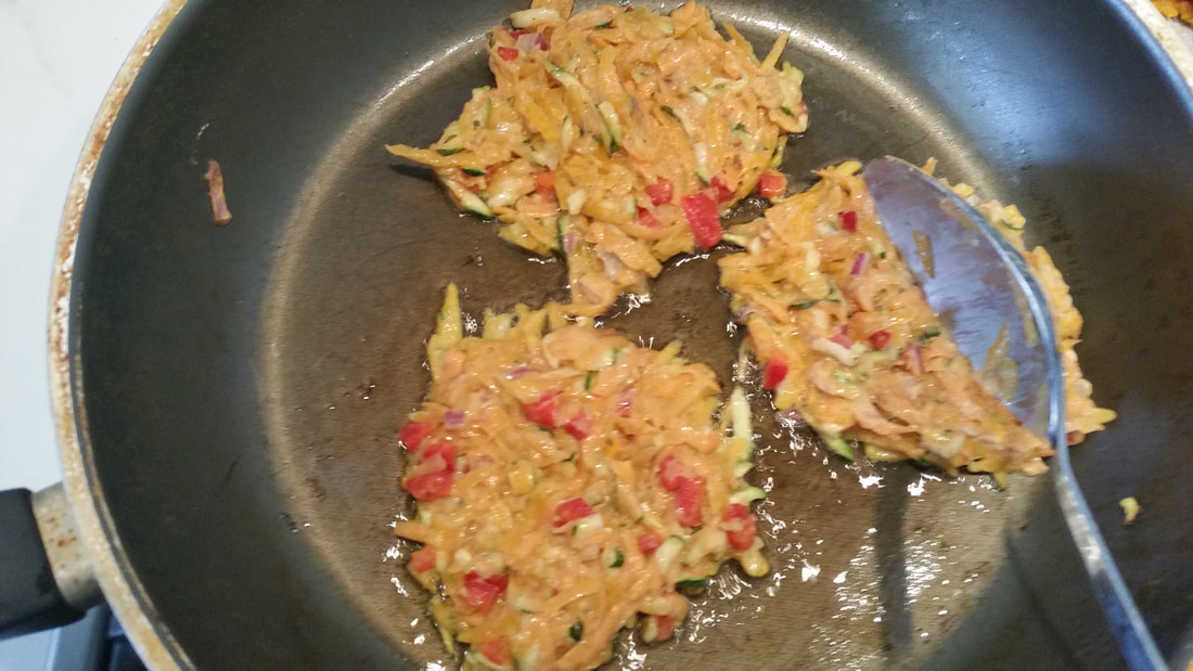 Spreading the veggie fritter mixture in the pan